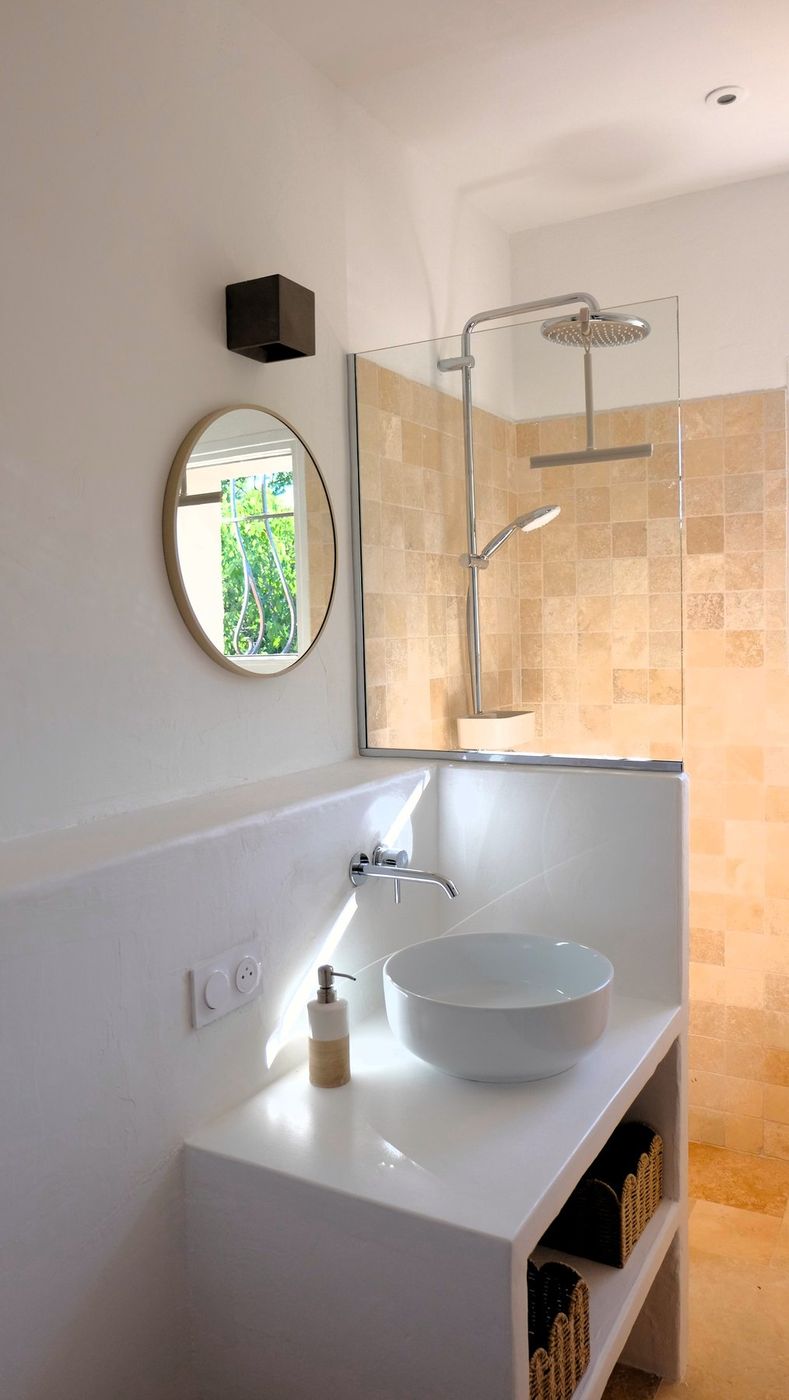 Badkamer met ronde spiegel en inloopdouche